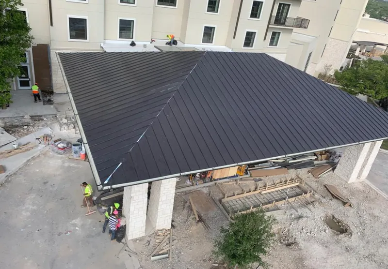 Metal roofing installation team working on a commercial building in Gorham